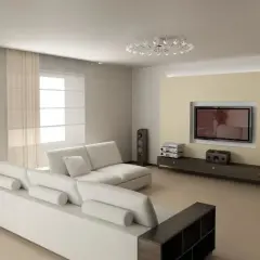 Nowoczesny salon z jasną sofą i telewizorem na tle beżowej ściany. Optyczne wydłużenie niskiego salonu triki z oświetleniem i farbą.