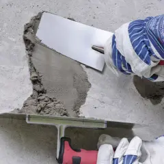 Naprawa betonu: wibrowanie betonu z gruszki zapobiega powstawaniu raków. Użycie kielni do wygładzenia zaprawy.