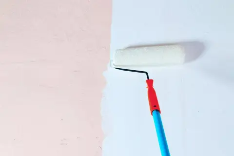 Test odporności na szorowanie: farba ceramiczna a lateksowa w kuchni. Wałek maluje białą ścianę obok różowej.
