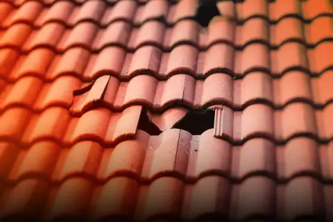 Pękanie dachówek na dachu po mroźnej zimie. Reklamacja u producenta jest konieczna, by naprawić uszkodzenia.