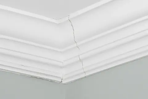 Pęknięta sztukateria ścienna w salonie. Jak samodzielnie rozplanować ramki, by uniknąć takich uszkodzeń?