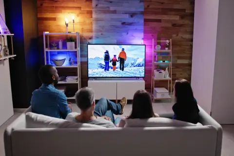 Rodzina ogląda film przy oświetleniu LED za telewizorem. Czy to nie męczy wzroku?