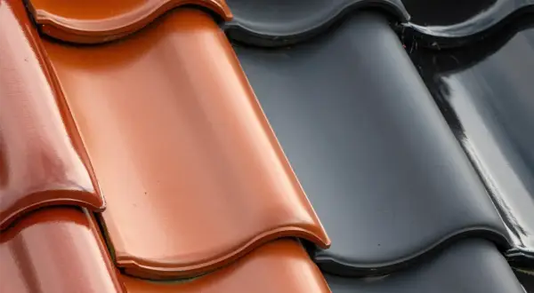 Dachówka ceramiczna czy betonowa? Zbliżenie na dachówki w kolorze rudym i grafitowym. Która lepiej tłumi hałas deszczu?