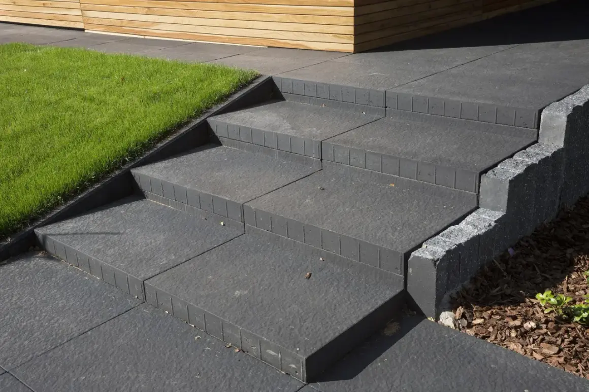 Schody z bloczków betonowych do ogrodu: praktyczny poradnik, jak samemu zrobić schody z bloczków betonowych do ogrodu, z zieloną trawą i drewnianą elewacją.