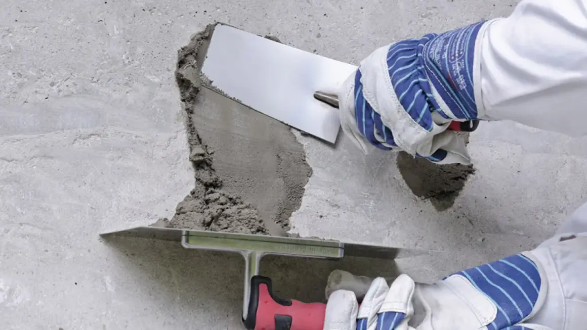 Naprawa betonu: wibrowanie betonu z gruszki zapobiega powstawaniu raków. Użycie kielni do wygładzenia zaprawy.