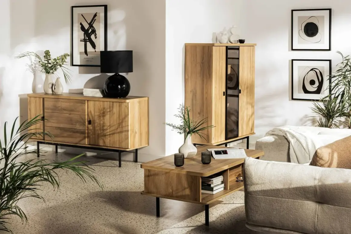Salon z drewnianymi meblami, czarną lampą i roślinami. Idealny przykład, jak połączyć styl loftowy z przytulnym boho w jednym salonie.