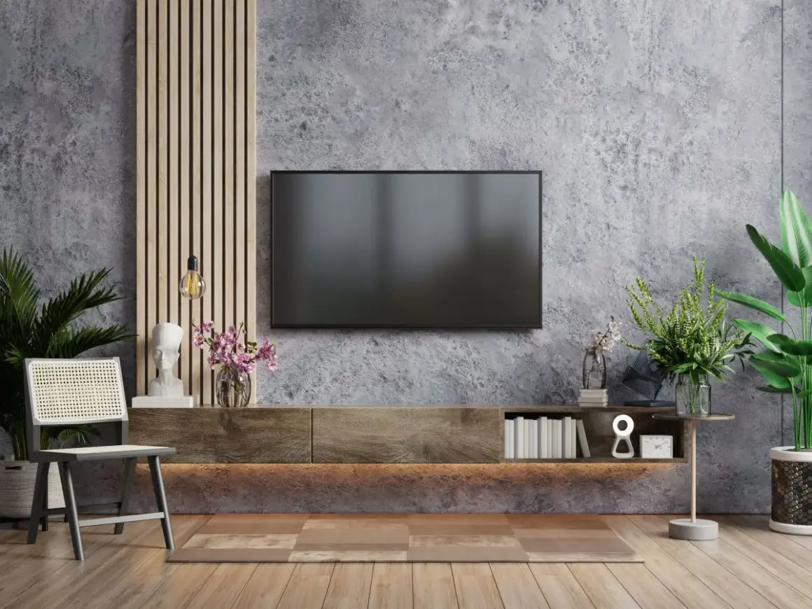 Ściana z telewizorem: beton architektoniczny, drewniane panele, rośliny i dekoracje. Alternatywa dla lameli.