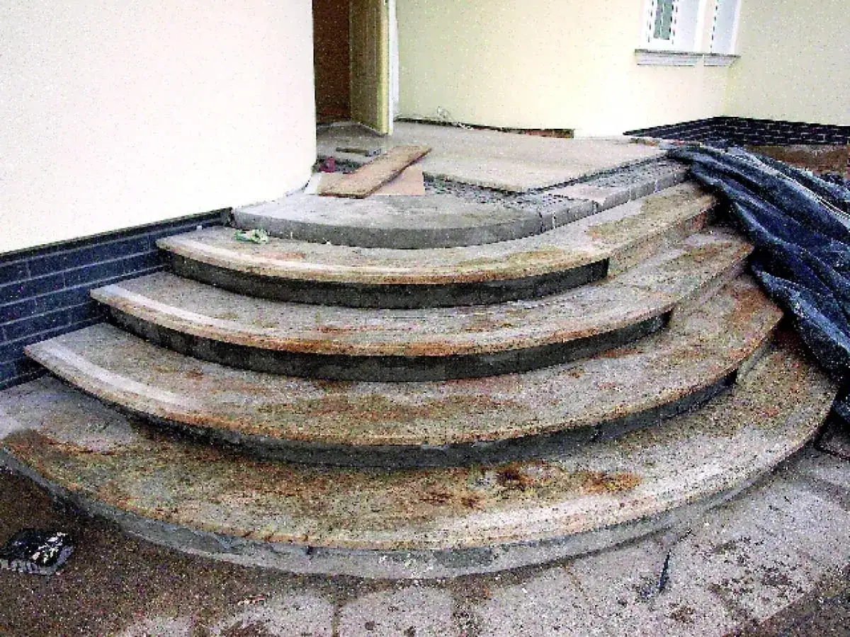 Schody betonowe przed położeniem płytek wymagają naprawy ubytków. Widać stopnie z widocznymi uszkodzeniami, gotowe do renowacji.