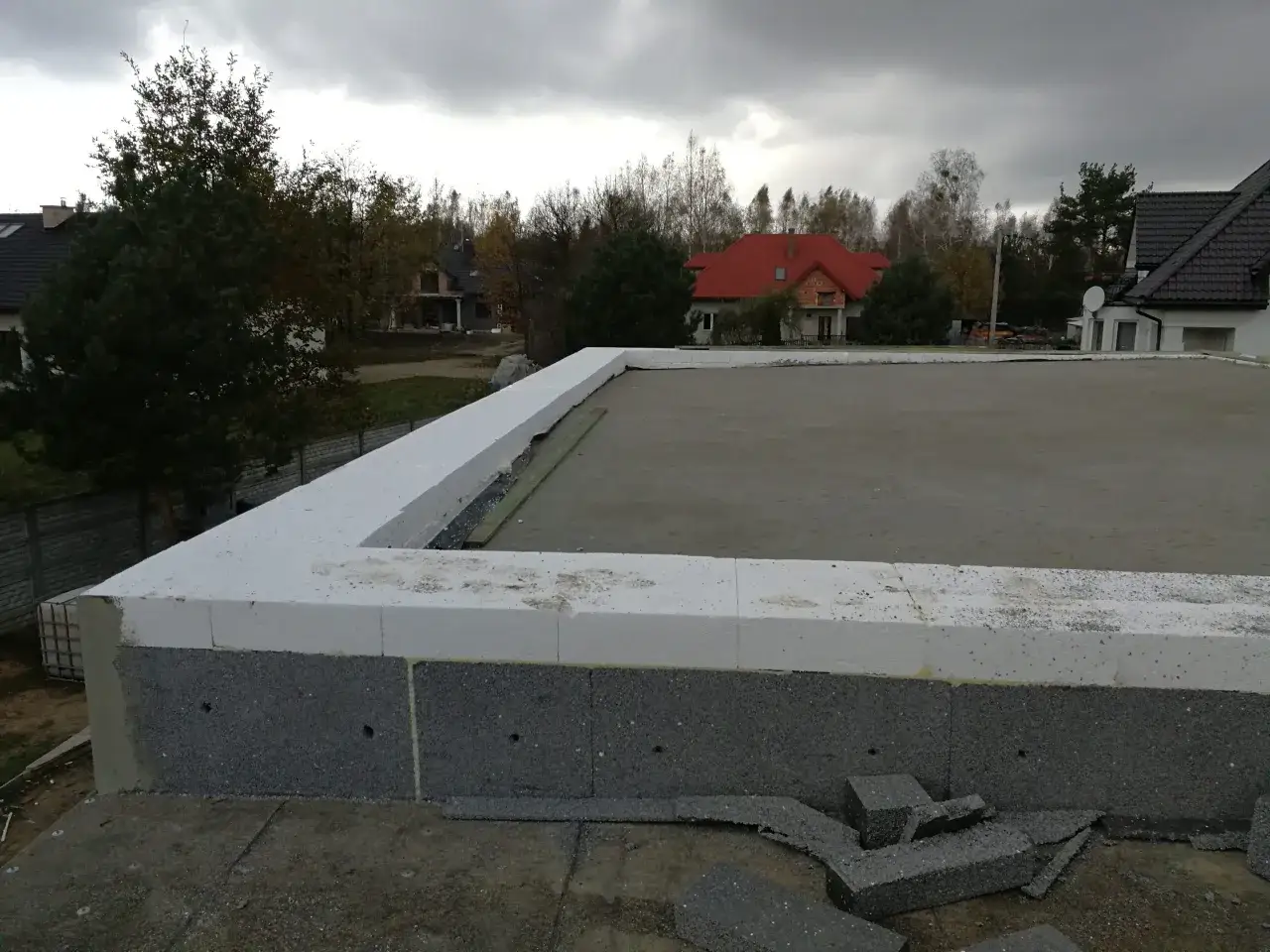 Ocieplenie dachu płaskiego styropianem spadowym: koszty i ukryte wady. Widoczna warstwa białego styropianu na krawędzi dachu.